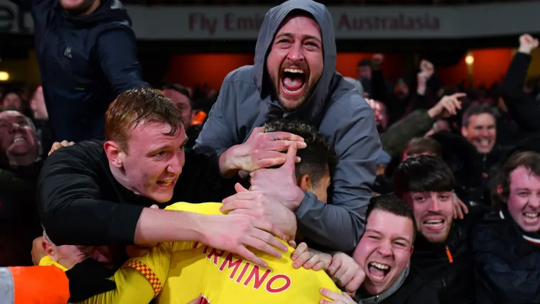 Roberto Firmino hugs Liverpool fans during the win at Arsenal