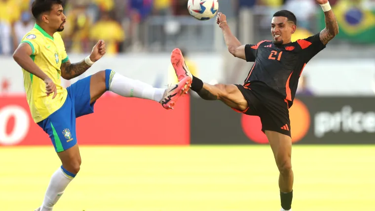 Brazil's Lucas Paqueta and Colombia's Daniel Munoz fight for a ball