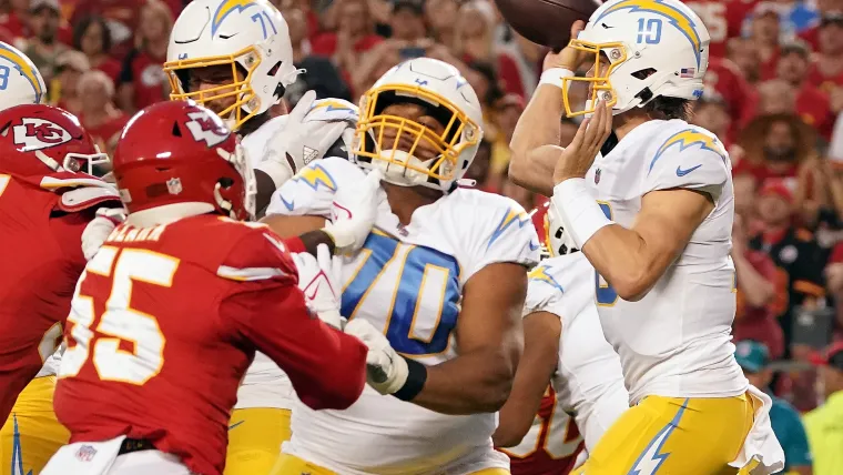 Chargers quarterback Justin Herbert (10) throws as offensive tackle Rashawn Slater (70) provides coverage