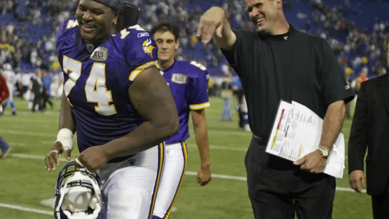 Minnesota Vikings left tackle Bryant McKinnie and head coach Mike Tice laughing on the sidelines.