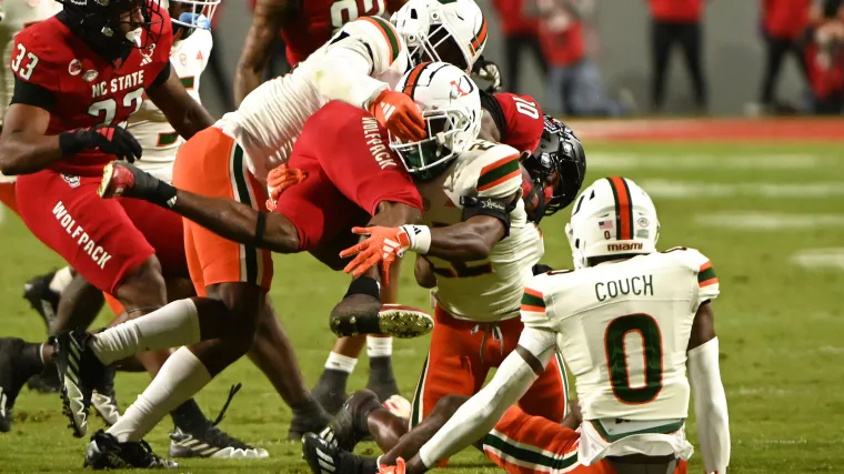 Nov 4, 2023; Raleigh, North Carolina, USA; North Carolina State Wolfpack receiver KC Concepcion (10) is tackled by Miami Hurricanes linebacker KJ Cloyd (23) during the first half at Carter-Finley Stadium. Mandatory Credit: Rob Kinnan-USA TODAY Sports