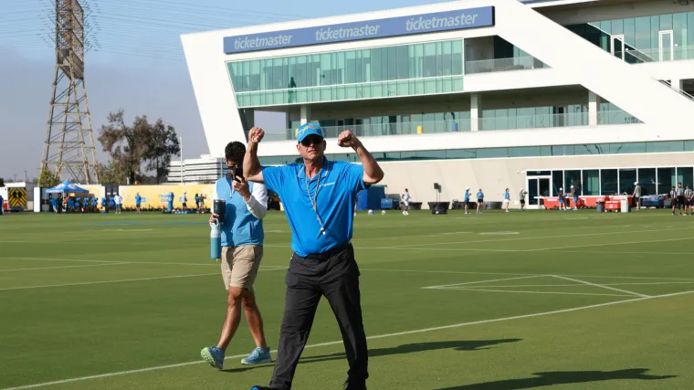 Los Angeles Chargers head coach Jim Harbaugh reacts with fans prior to the first day of training camp