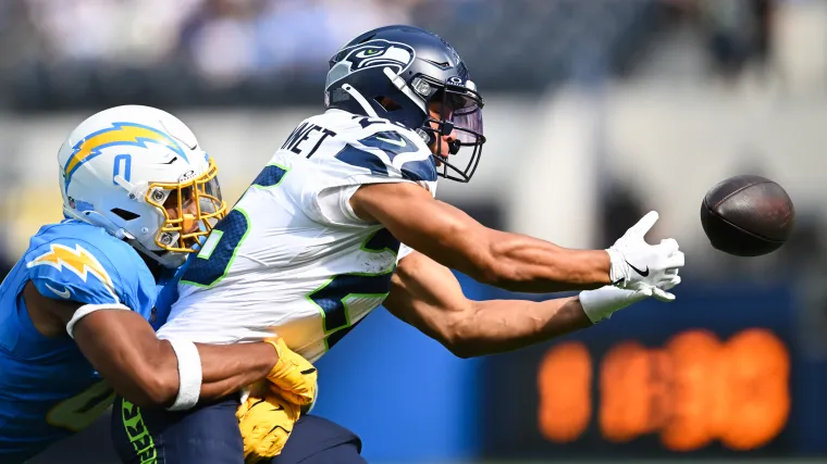 Seattle Seahawks running back Zach Charbonnet (26) attempts to catch the ball against Los Angeles Chargers linebacker Daiyan Henley (0)