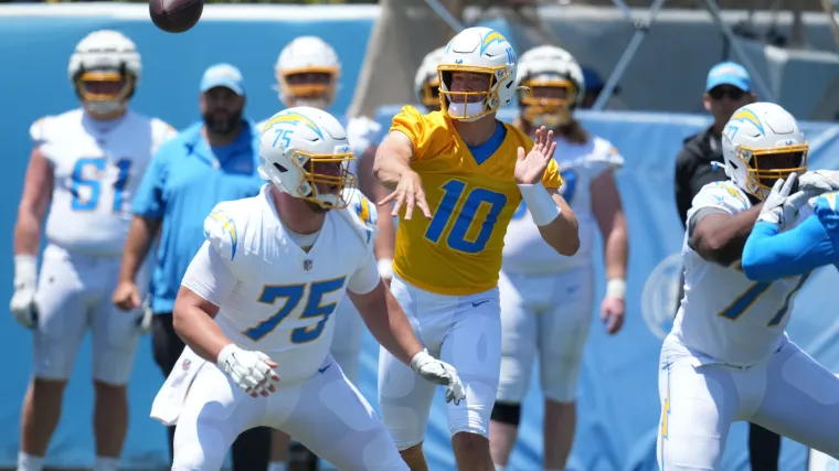 Los Angeles Chargers quarterback Justin Herbert (10) throws the ball as center Bradley Bozeman (75) and guard Zion Johnson (77) defend